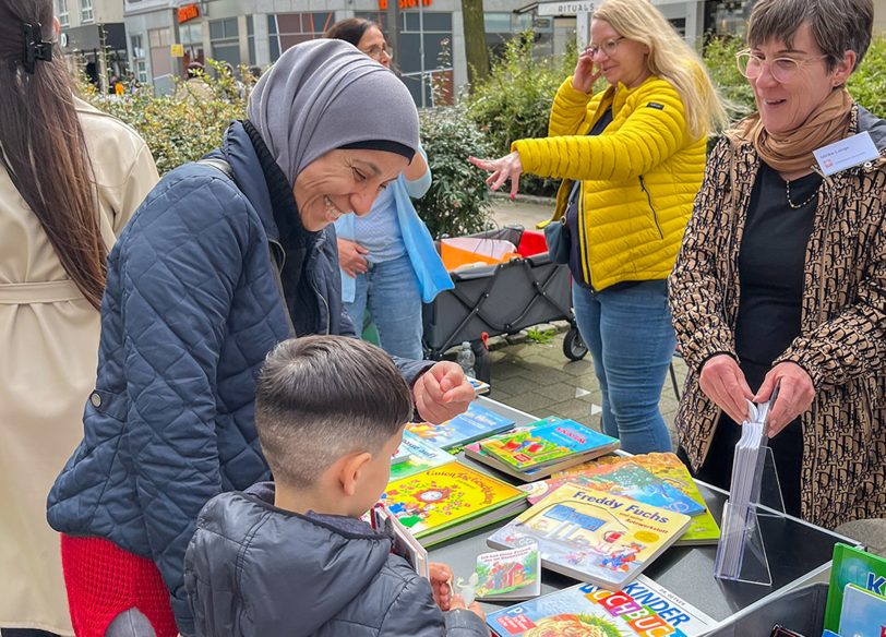 Ulrike Lange vom Caritas-Quartiersbüro (r.) und ihre Kolleginnen laden Groß und Klein zum Stöbern in vielfältigen Kinderbüchern ein (Archivfoto).