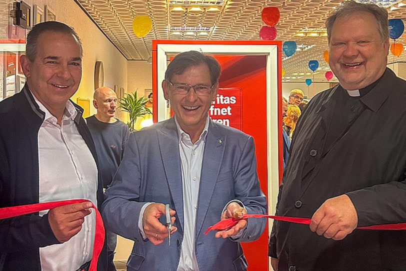 v.l. Caritas-Vorstand Ansgar Montag, Oberbürgermeister Dr. Frank Dudda und Dechant Ludger Plümpe durchschneiden das symbolische rote Band zur Eröffnung des Caritas Quartiersbüro.