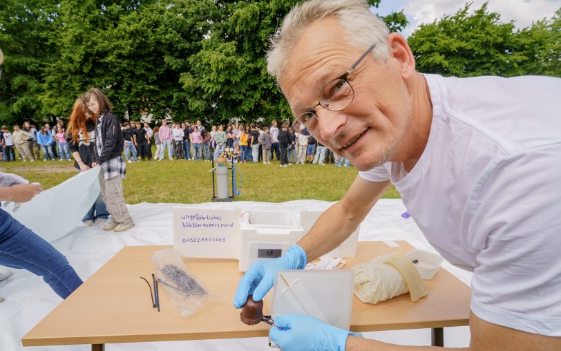 Lehrer Stefan Helling befestigt einen Schokokuss am Ballon.
