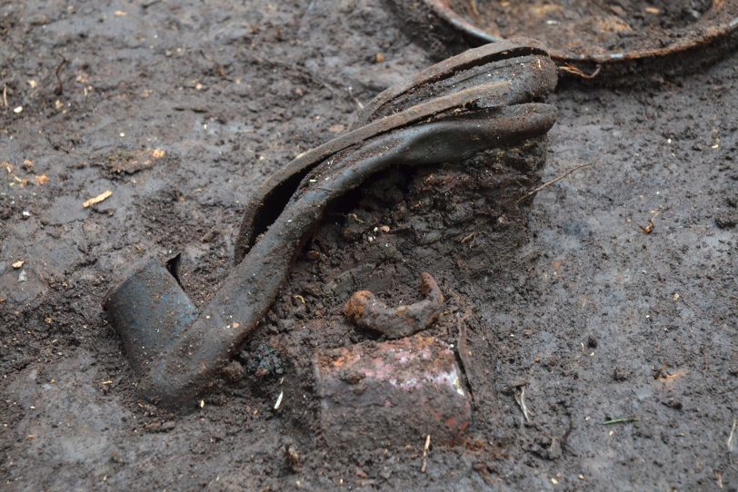 Hier ein Damenschuh in Fundlage bei Ausgrabungen zu NS-Verbrechen an Zwangsarbeitern im Sauerland 1945.