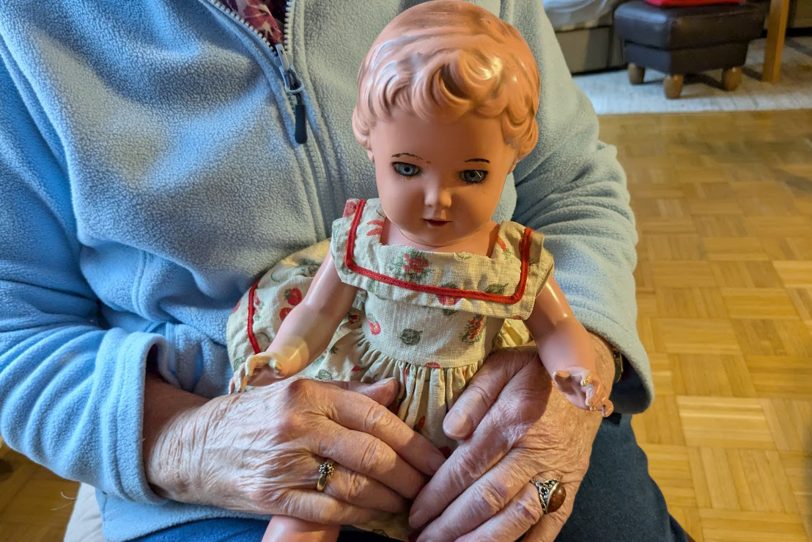 Die 91-jährige Reni Schulz erinnert sich an ihre 'Weihnachtspuppe', die bei der Rückkehr nach Kriegsende in Pommern bleiben musste. Im Arm hat sie die Puppe ihrer Tochter, die sie ihr in Erinnerung an ihre eigene Puppe 20 Jahre später schenkte.