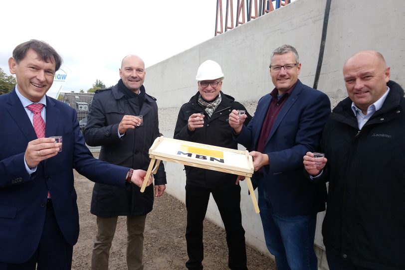 Frank Dudda (l.) und Thomas Bruns (2.v.l.) stoßen aufs Richtfest an