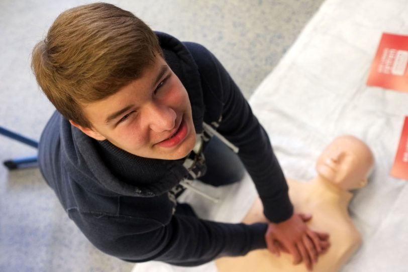 Maximilian übt die Herzdruck-Massage an der Reanimations-Puppe.