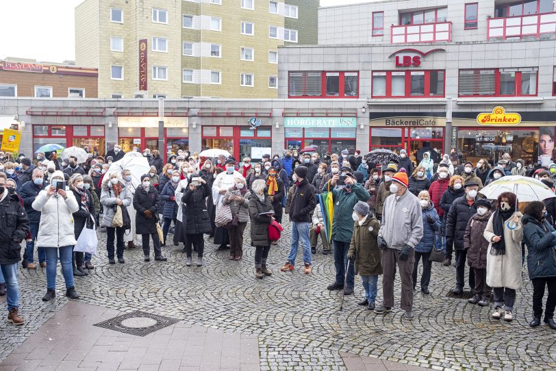 Friedensgebet an der Kreuzkirche in Herne (NW), am Samstag (22.01.2022). Seit einigen Wochen haben sich das Bündnis Herne, die Schirme gegen Rechts, die katholische Kirchengemeinde St. Dionysius, die Islamische Gemeinde Röhlinghausen und die evangelische Kreuz-Kirchengemeinde zusammengeschlossen, um ein Zeichen für ein solidarisches Miteinander in der Pandemie zu setzen und den Opfern der Pandemie zu gedenken. Im Bild: die anschließende, gemeinsame Veranstaltung auf dem Robert-Brauner-Platz.