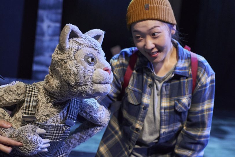 Dongmin Lee mit der Klappmaulpuppe der karierten Katze.