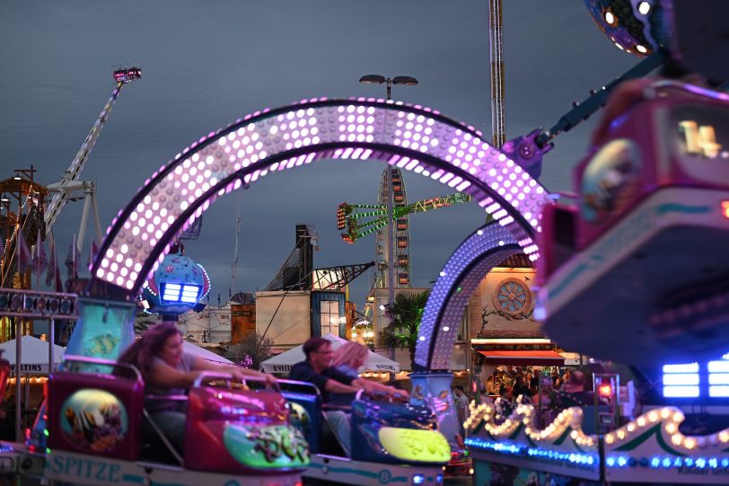 Die abendliche Cranger Kirmes mit Hochfahrbetrieb Evolution, Rundfahrbetrieb Konga und Riesenrad Jupiter. Im Vordergrund Rundfahrbetrieb Big Monster Riesenrad Jupiter, Kettenkarussel Wellenflug Blick auf die Cranger Kirmes von der Rathausstraße aus. Im Bild Riesenrad Jupiter, Hochfahrbetrieb Evolution sowie der Turm vom Hochfahrbetrieb Hangover The Tower