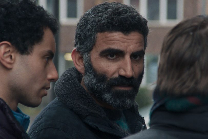 Said (Mehdi Meskar) und Mustafa (Aziz Çapkurt) wollen bei der Praktikantin Elif die Herausgabe der Reste des verbrannten Koran erreichen.