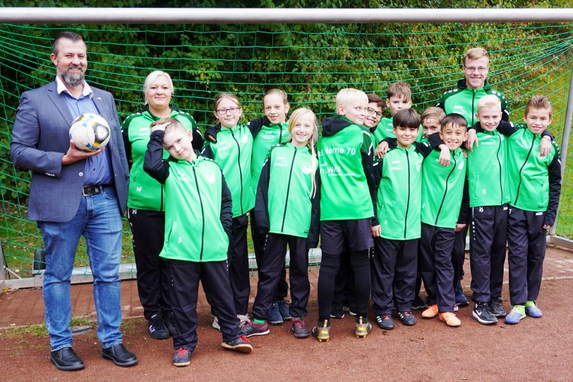 Neue Trainingsanzüge für die Nachwuchskicker der SG Herne 70, gestiftet von der Wohnungsgenossenschaft Herne-Süd eG (WHS): Mit dabei die Trainer Melanie Feronato (2.v.li.) und Marcel Klein (re.) sowie WHS-Prokurist Marco Volkar (li.).