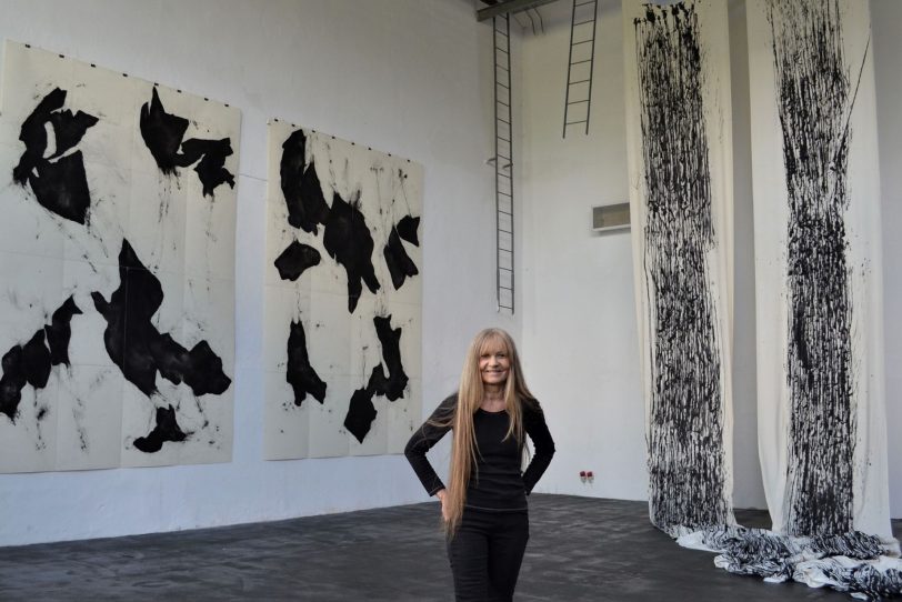 Daniela Baumann in der Schwarzkaue vor ihren Großformaten und der Installation.