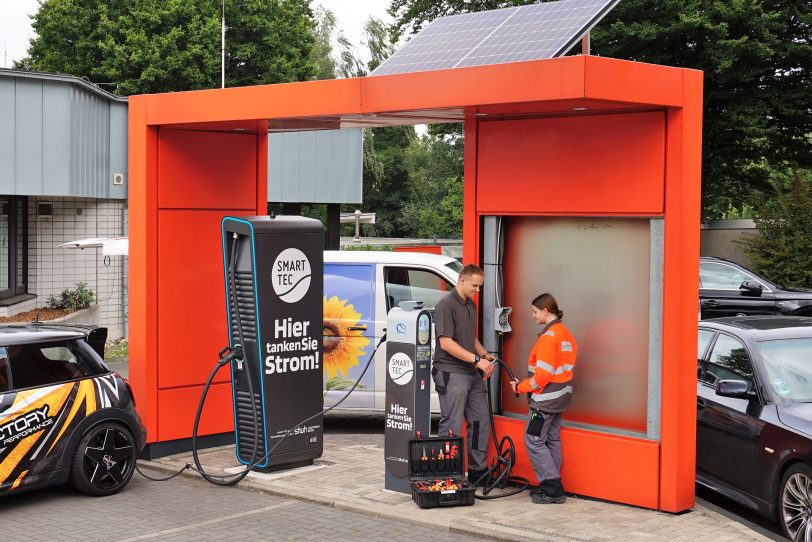 Tobias Scholz und Christin Pieda (v.l.), Elektro-Azubis bei den Stadtwerken, schließen das Solarmodul an die Ladesäulen am Grenzweg an.