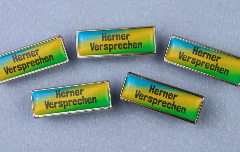 Das Bündnis Herne verteilte Pins, die an das 'Herner Versprechen' erinnern sollen, an alle demokratischen Ratsmitglieder.