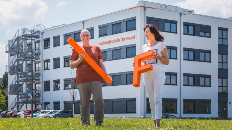 Neue Leucht-Elemente der Fachhochschule am Campus Emil-Figge-Straße präsentieren Marion Kriewaldt-Paschai (Dezernentin Hochschulkommunikation) und Martin Hübner (Dezernent Facilitymanagement).
