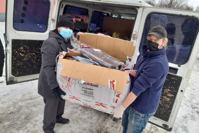 v.l. Tuncay Nazik (Islamische Gemeinde) und Kai (Suppenküche) laden den Transporten mit Hilfsmitteln aus.