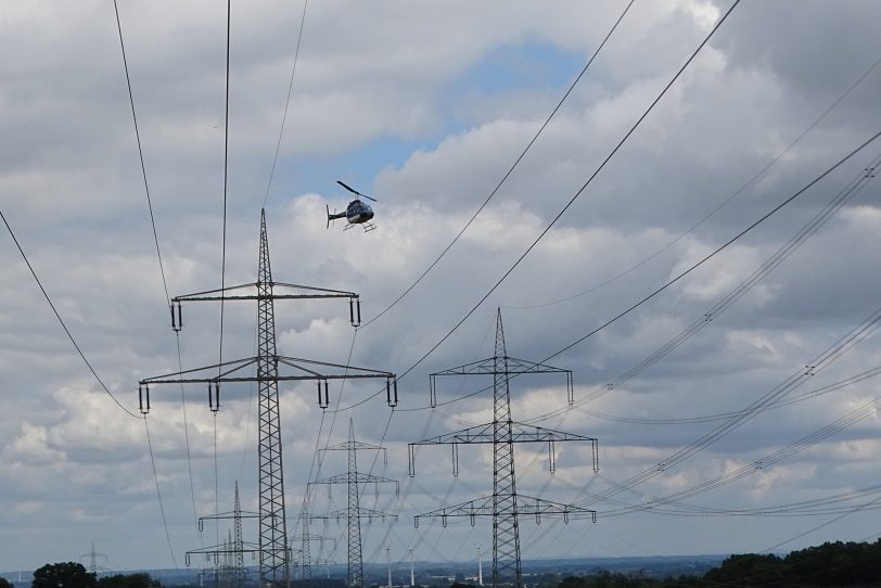 Der Übertragungsnetzbetreiber Amprion prüft seine Höchstspannungsfreileitungen vom Hubschrauber aus.