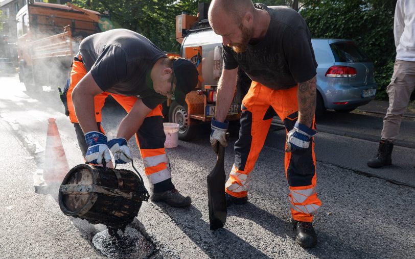 Mitarbeiter der Straßenmeister verfüllen Schlaglöcher auf Hernes Straßen.