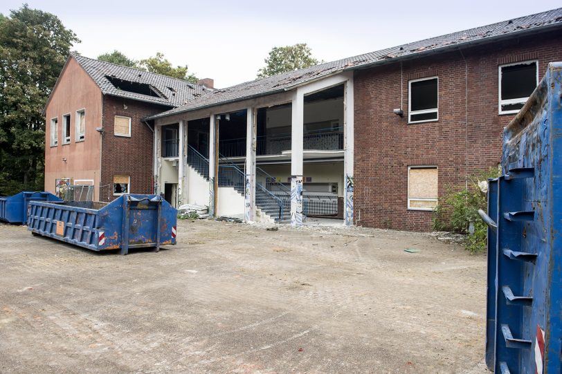 Container vor dem ehemaligen Schulgebäude.