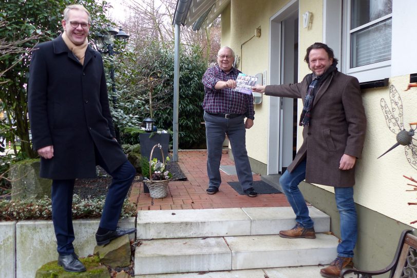 Jens Koch (r.), Geschäftsführer der Diakonie Ruhr, und Superintendent Gerald Hagmann überreichen die Dankesschrift an Werner Neveling.