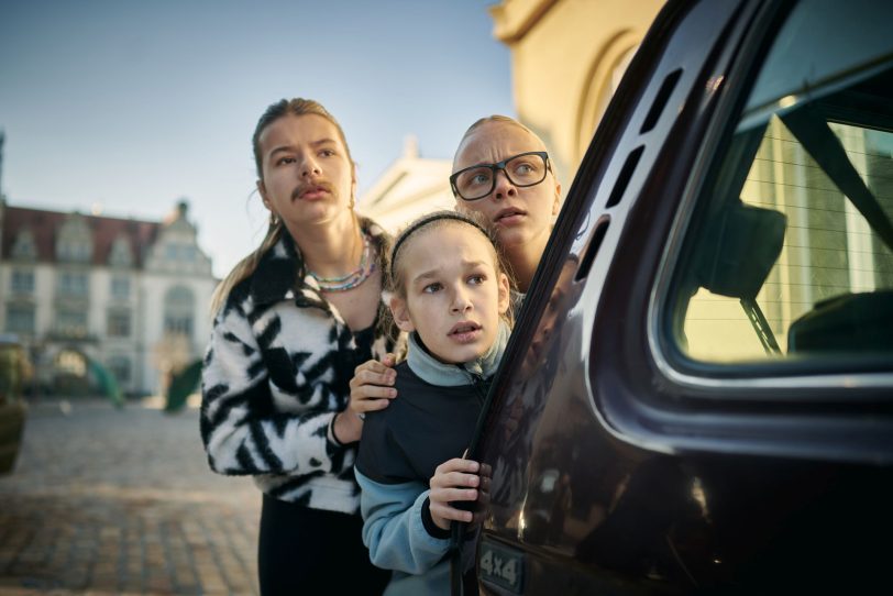 Tammi (Elisabeth Bellé) schaut sich mit ihren zu Freunden gewordenen Verwandten Umbo (Noèl Gabriel Kipp) und Keks (Lale Andrä) das Chaos an, dass die drei Geister in Bernburg angerichtet haben.