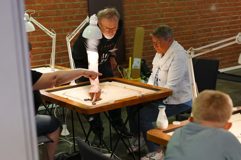 Hilfestellung bei dem Spiel Carrom