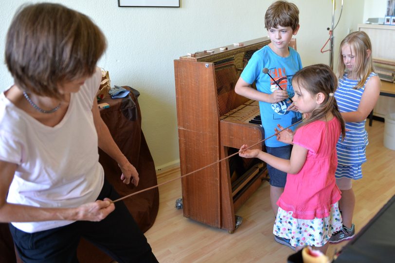 Sigrid Eul beim Klavierpuzzle mit Emily, Micha und Greta.