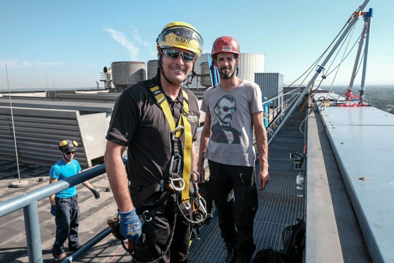 Industriekletterer bringen am Kesselhaus Block 4 der Steag AG in Baukau eine Werbetafel an.