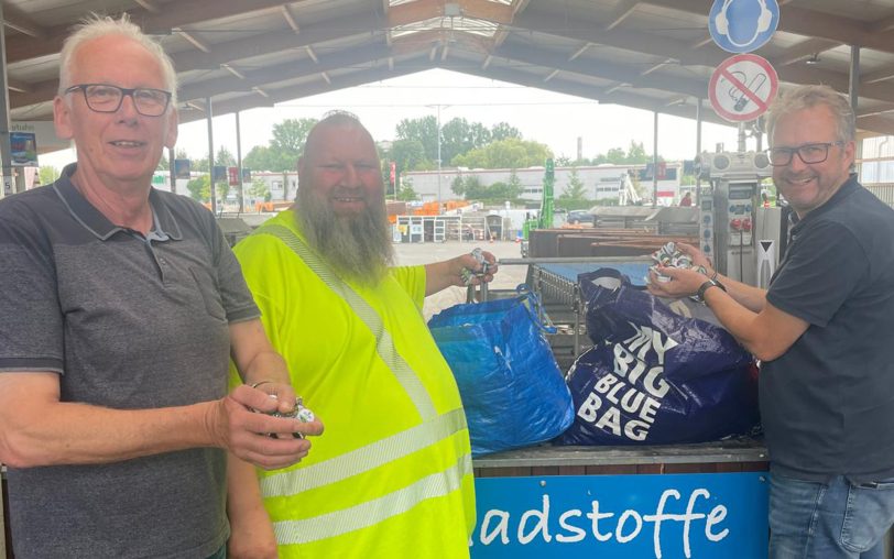 Der Geschäftsführer der SG Westfalia Herne, Lars Reidt (re.), übergab am Recyclinghof von Entsorgung Herne mehrere Tüten mit Kronkorken.
