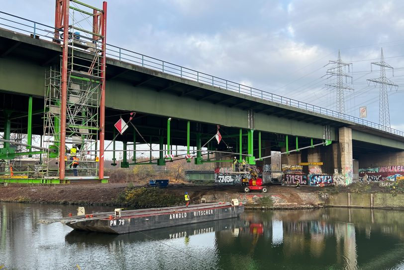 Der erste Zugstab wird vom Ponton-Schiff aus unter der A43-Brücke über den Rhein-Herne-Kanal eingebaut.