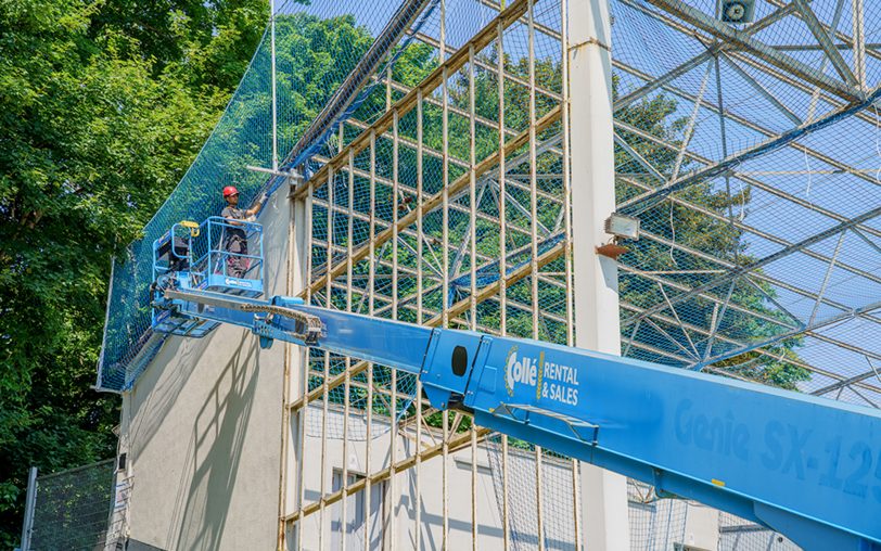 Arbeiter sind an den Seitenwänden beschäftigt.