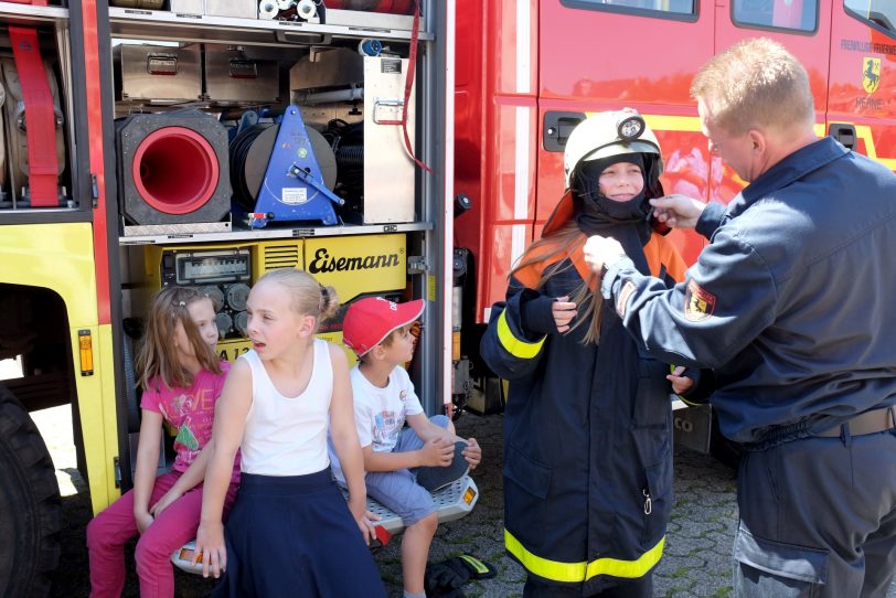 Eltern und Kinder zu Besuch bei der Feuerwehr.