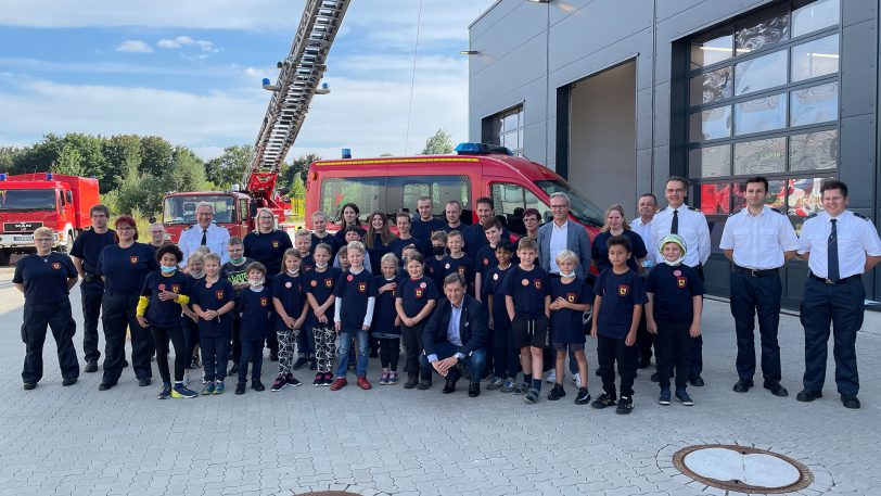 Alle gemeinsam vor dem neuen Fahrzeug: Die Kinder, Betreuer, Oberbürgermeister, Dezernent und die Feuerwehrleute.