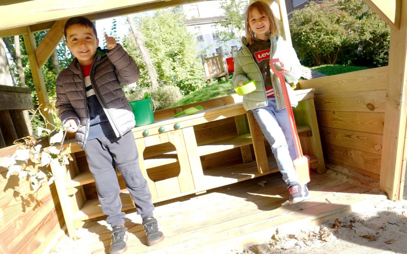 Lounis (li.) und Louisa freuen sich über die neue Matschküche für die Kita am EvK Herne. Gespendet wurde sie durch die Woges-Projektförderung.