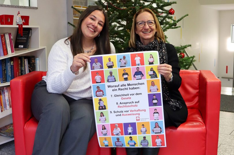 v.l. Jil Trieschmann und Andrea Sudkamp aus der Caritas-Unternehmenskommunikation präsentieren die neue Fotocollage zum Tag der Menschenrechte.