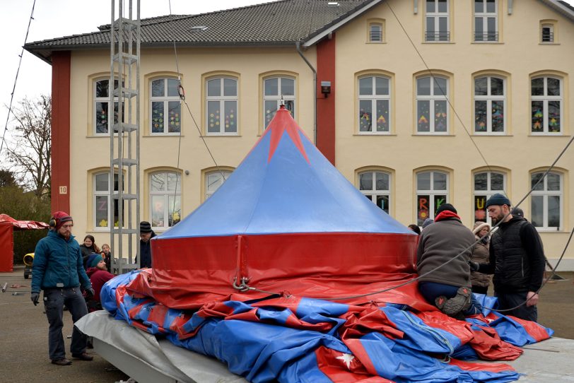 Der Kinder- und Jugendzirkus Dobbelino macht Station an der Grundschule in Holsterhausen, der Sonnenschule. Am Sonntag bauten das Zirkusteam Eltern und Lehrer das Zelt auf dem Schulhof auf.