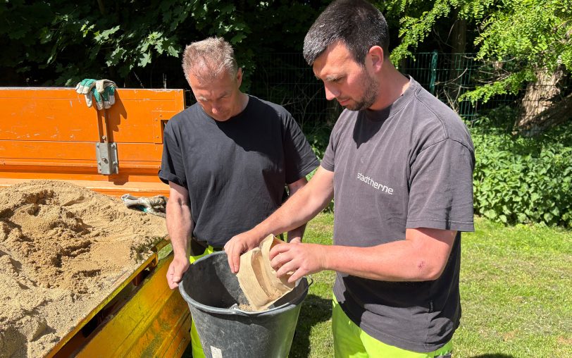 Zwei Mitarbeiter vom Fachbereich Stadtgrün haben die Eimer mit der Saatgut und Sand gemischt, die dann großflächig verteilt wurden.