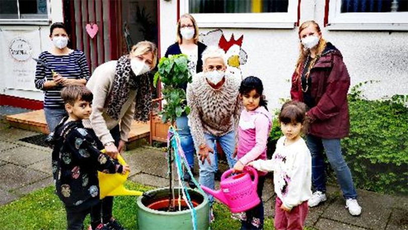 Die Erzieherinnen und Kinder der Kita Am Weustenbusch pflanzten einen besonderen Apfelbaum, um die Sprachentwicklung zu fördern.