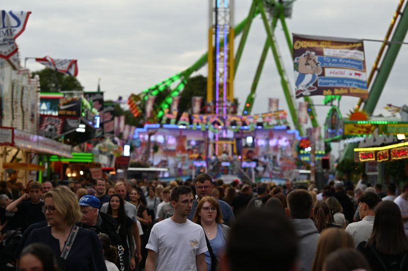 Besucher der Cranger Kirmes  Riesenrad Jupiter, Kettenkarussel Wellenflug Blick auf die Cranger Kirmes von der Rathausstraße aus. Im Bild Riesenrad Jupiter, Hochfahrbetrieb Evolution sowie der Turm vom Hochfahrbetrieb Hangover The Tower