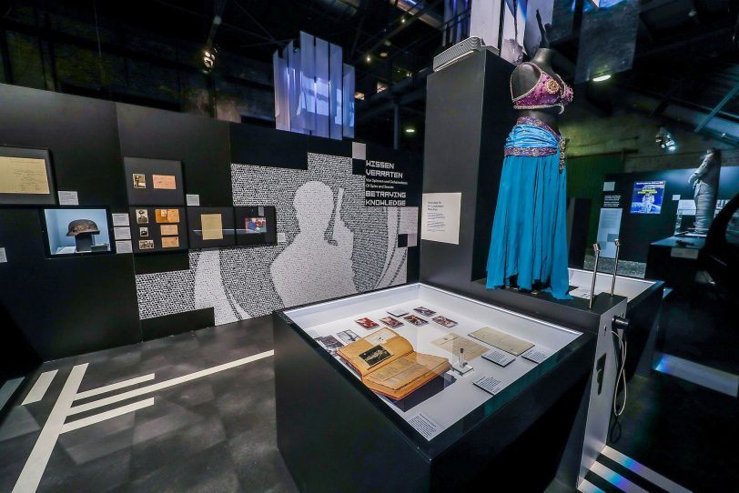 Blick in die Ausstellungseinheit zur Spionage. Links hinten in der Vitrine Hasenjaegers Helm mit den Einschusslöchern.