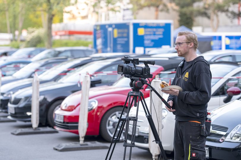 Die 1. Ruhrpott Comedy Nacht von LMV Veranstaltungsservice Herne im Autokino auf dem Parkplatz im Revierpark Gysenberg in Herne (NW), am Samstag (25.04.2020). Auf der Bühne standen an diesem Abend der Moderator und Comedian Helmut Senftenschneider, der aus Istanbul stammenden Comedian Serhat Dogan und der Duisburger Kabarettist und mehrfache Kleinkunstpreisträger Kai Magnus Sting. Im Bild: Kameramann mit Bratwurstbrötchen.