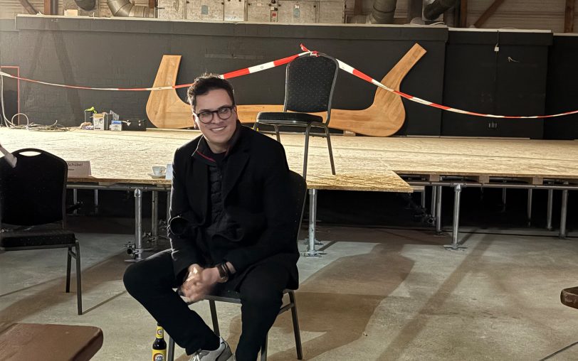 Marvin Boettcher sitzt entspannt und schaut den Bauarbeitern zu - vier Wochen sind es mit Stand von Donnerstag (12.2.2026) bis zur Premiere.