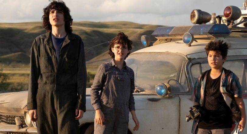 Die jungen Geisterjäger Trevor (Finn Wolfhard), Phoebe (McKenna Grace) und Podcast (Loghan Kim) am Ecto-1.