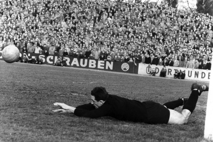 Hans Tilkowski im Stadion am Schloss Strünkede, 1959. Im Hintergrund ist die Bandenwerbung von „Dorn-Schrauben“ zu erkennen. Tilkowski absolvierte dort seine Ausbildung.