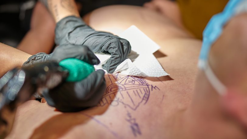 Personen mit halbfertigen bunten Tattoos müssen erstmal warten.