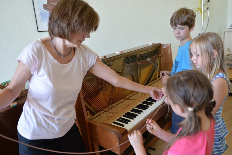 Sigrid Eul beim Klavierpuzzle mit Emily, Micha und Greta.