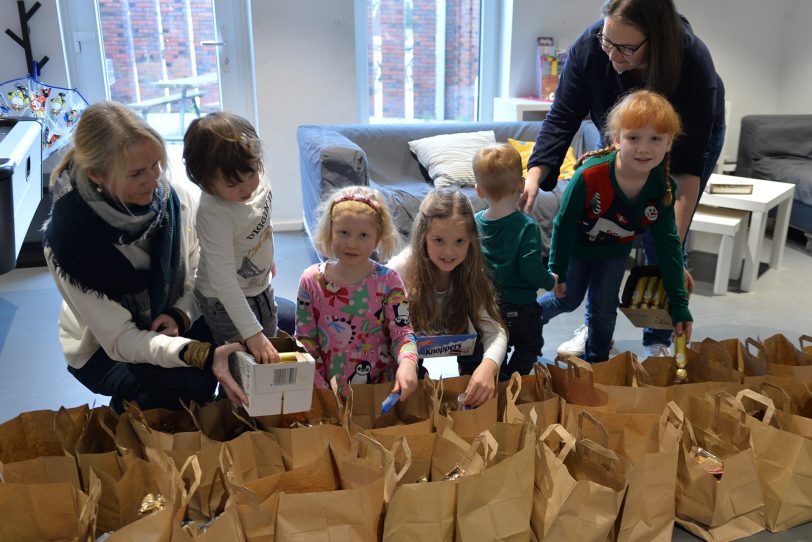 Die Aktion des CVJM Herne 'Heilig Abend nicht allein': Viele kleine Hände helfen beim Befüllen der Geschenktüten.