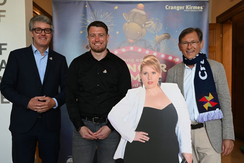 Freuen sich auf die Eröffnung der Cranger Kirmes: (v.l.) Dr. Alexander Christian, Platzmeister Alexander Neumann und Dr. Frank Dudda präsentieren den musikalischen Stargast der Cranger Kirmes 2025, Maite Kelly.