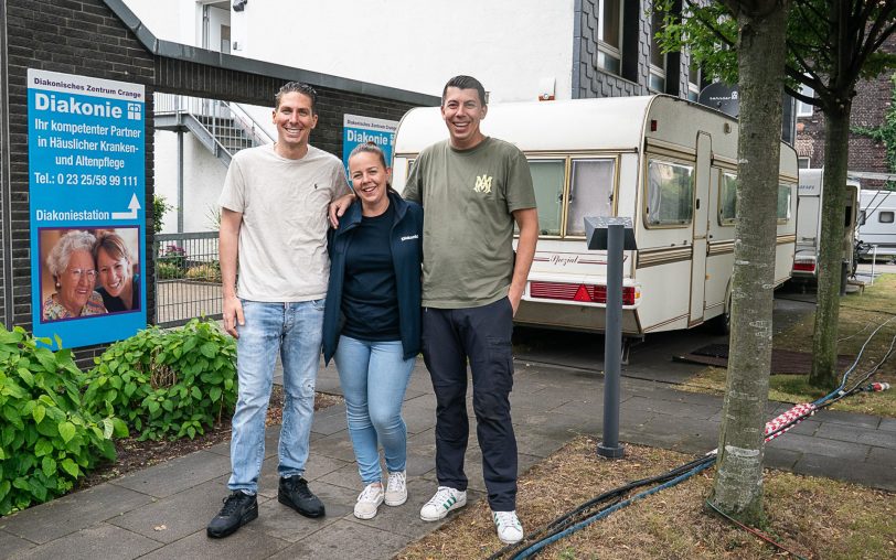 Prima Nachbarn auf Zeit: die Schausteller Xavier (links) und Ricardo Galle mit Wiebke Mücke, Pflegedienstleiterin der Tagespflege, auf dem Gelände der Diakoniestation an der Dorstener Straße.