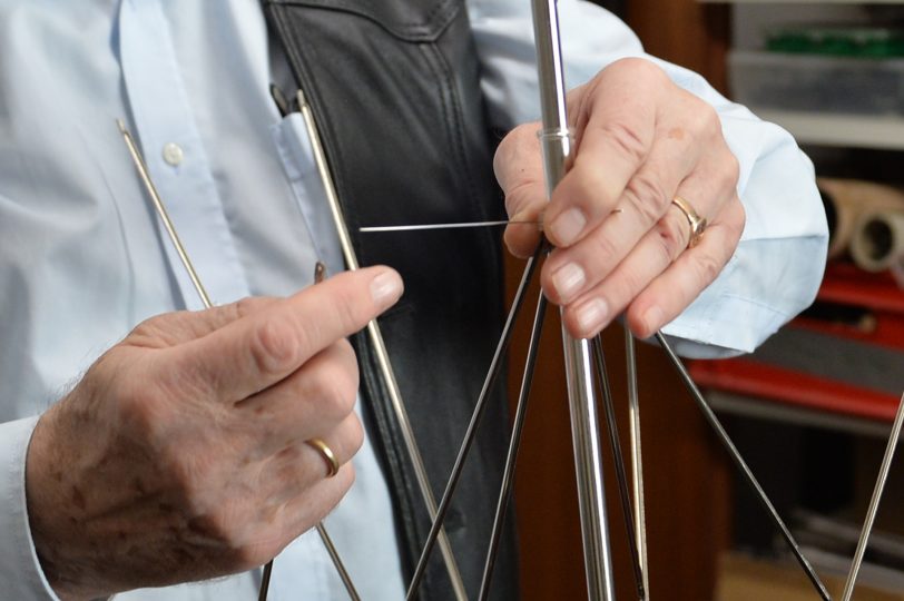 Schirmmacher-Meister Willy Schüffler verdrahtet in Handarbeit das Gestänge.