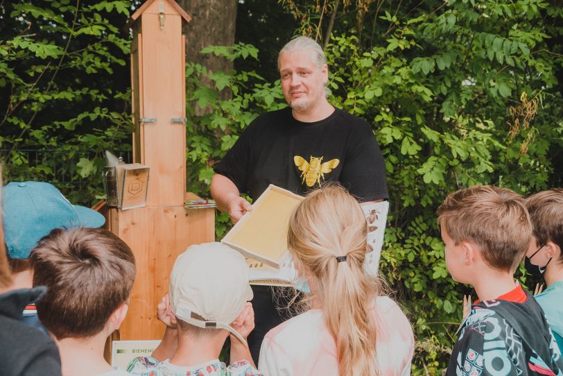 Imker Jens Busch von der Bee Academy zeigt Kindern das Schaubienenvolk im Tierpark.