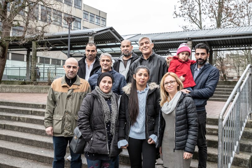 Eltern vor dem Schulgebäude. Mit dabei die Kultur-und Sprachmittler Ahmed Al- Sayed (hinten, Mitte), Hacer Karaeli (vorne, 2. v.r.) und Ionela Ghenov (vorne, r.).